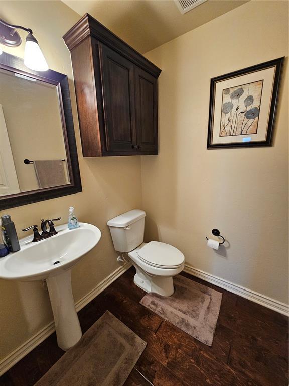 bathroom with wood-type flooring, sink, and toilet