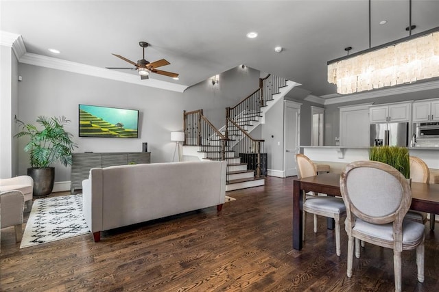 living room featuring dark hardwood / wood-style floors, ceiling fan with notable chandelier, and ornamental molding