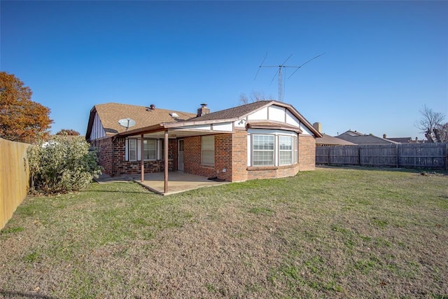 rear view of house with brick siding, a lawn, a patio area, and a fenced backyard