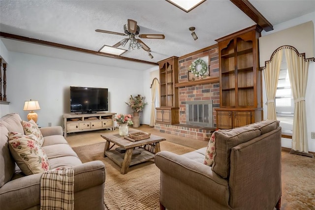 living area with built in features, ceiling fan, a textured ceiling, carpet floors, and a brick fireplace