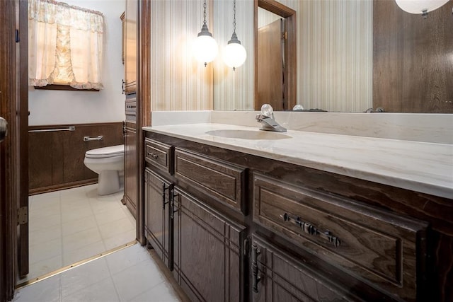 bathroom with tile patterned flooring, vanity, and toilet