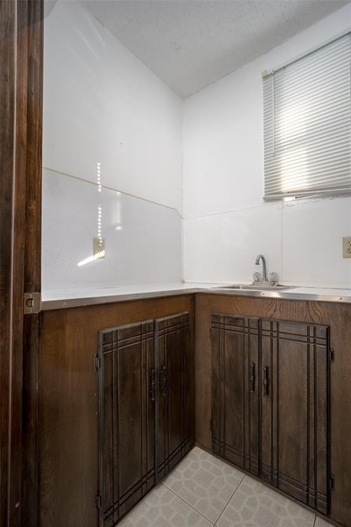 kitchen with dark brown cabinetry and a sink