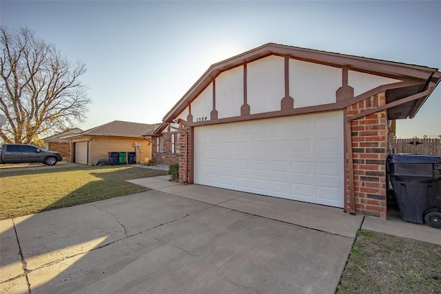 exterior space featuring a garage, a front lawn, concrete driveway, and brick siding