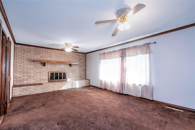 unfurnished living room featuring ceiling fan, a brick fireplace, crown molding, and dark colored carpet