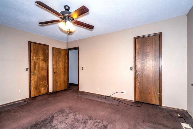 unfurnished bedroom with ceiling fan and dark carpet