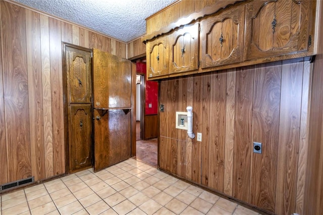 kitchen with wood walls and a textured ceiling