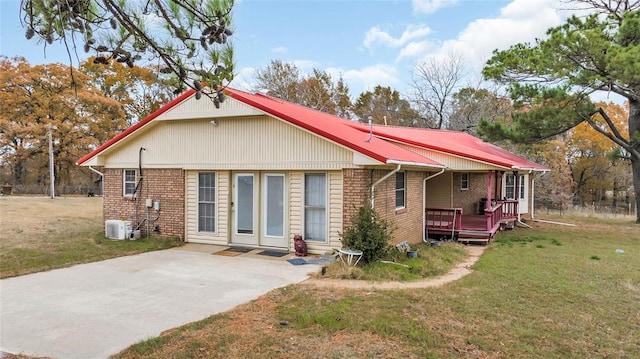 view of front of home featuring a front yard and central AC