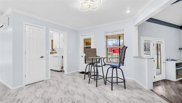 dining room featuring washer / clothes dryer, crown molding, and light hardwood / wood-style flooring