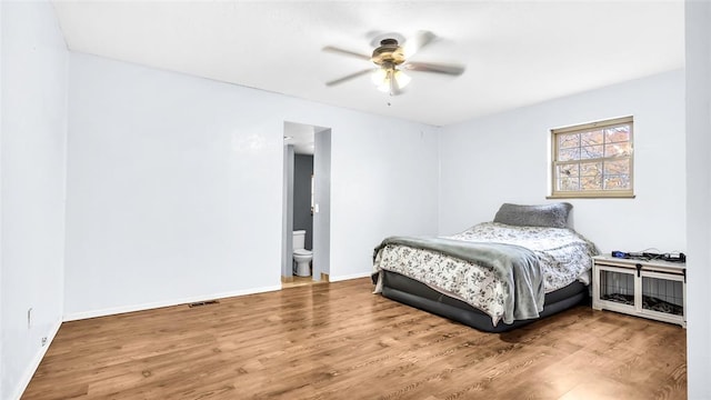 bedroom featuring hardwood / wood-style floors, ensuite bathroom, and ceiling fan