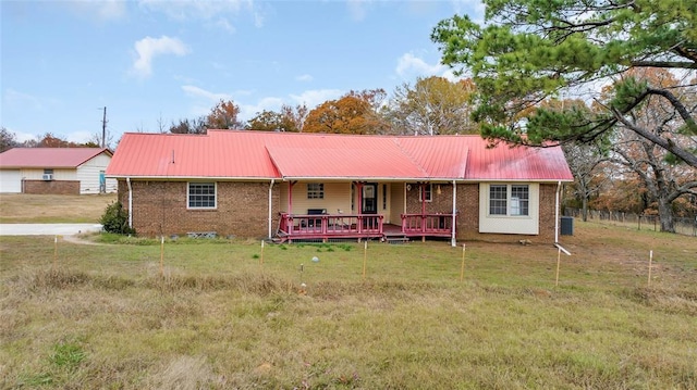 view of front facade featuring metal roof, brick siding, and a front yard