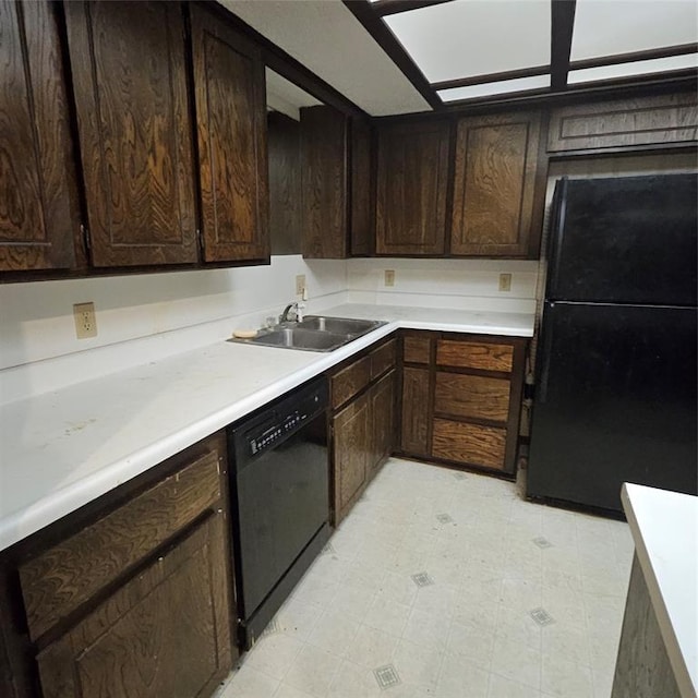 kitchen featuring black appliances, dark brown cabinetry, and sink