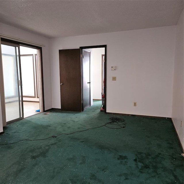 carpeted spare room featuring a textured ceiling