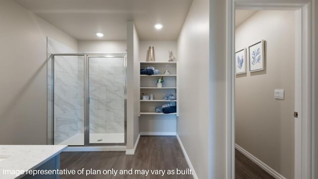 full bathroom with a stall shower, baseboards, wood finished floors, and vanity