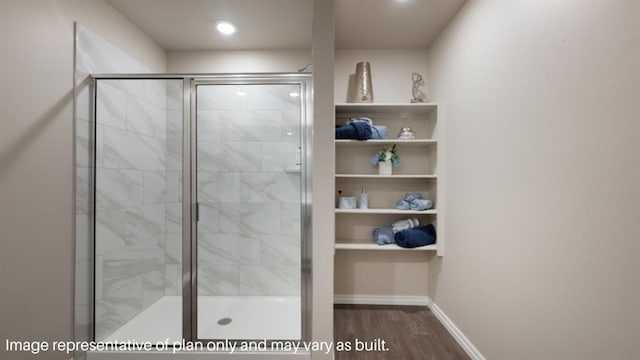 full bath with a shower stall, baseboards, and wood finished floors