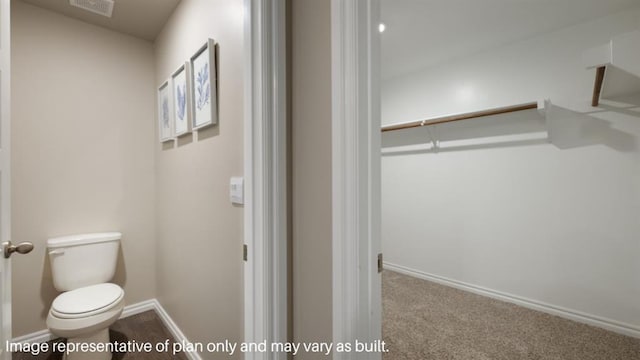 bathroom featuring toilet, visible vents, and baseboards