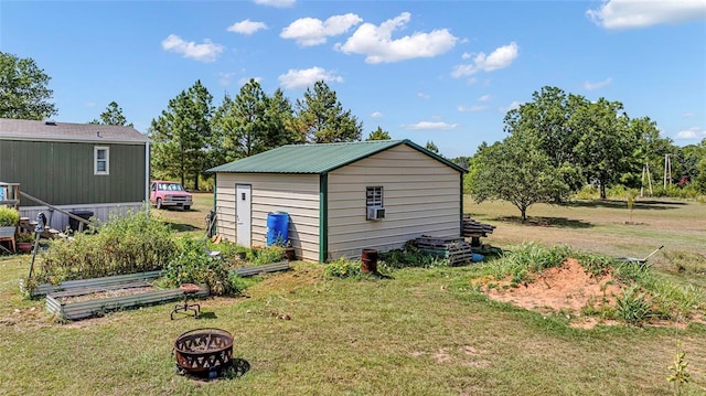 view of outbuilding with a fire pit and a yard