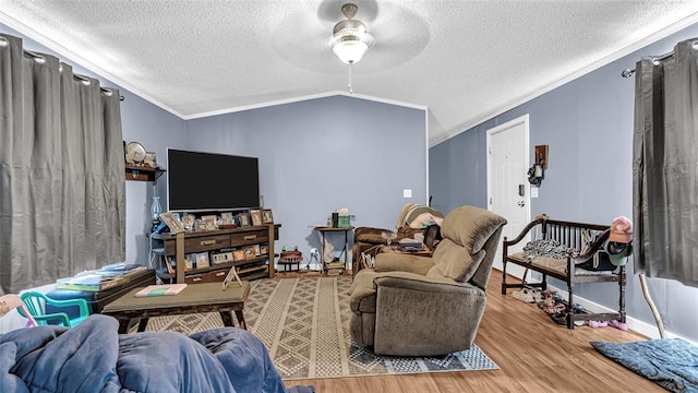 living room featuring lofted ceiling, crown molding, ceiling fan, a textured ceiling, and wood-type flooring