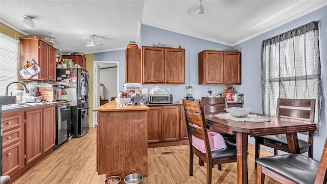 kitchen with black appliances, light wood-type flooring, sink, and vaulted ceiling