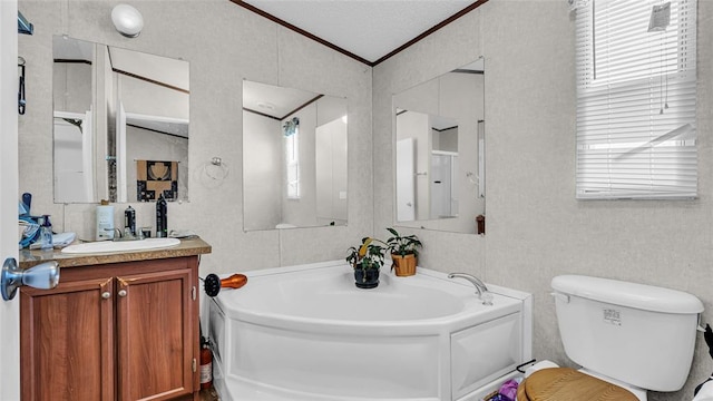 bathroom with ornamental molding, vanity, a textured ceiling, a bath, and toilet