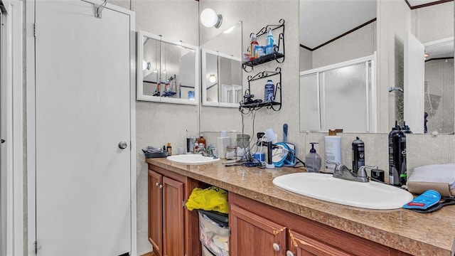 bathroom featuring crown molding, vanity, and a shower with shower door