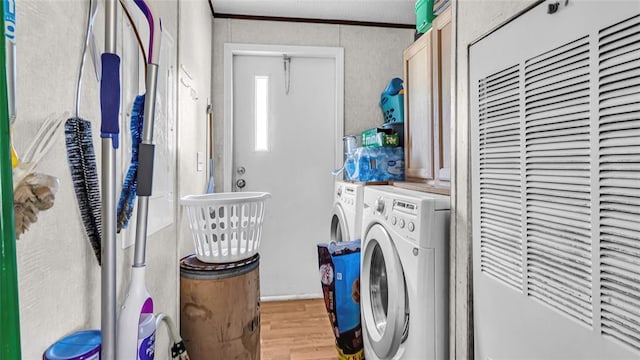 washroom featuring cabinets, light hardwood / wood-style flooring, washer and dryer, and ornamental molding