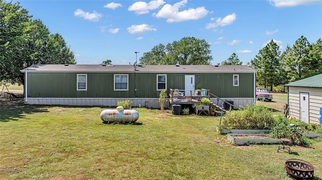 back of house with a deck and a yard