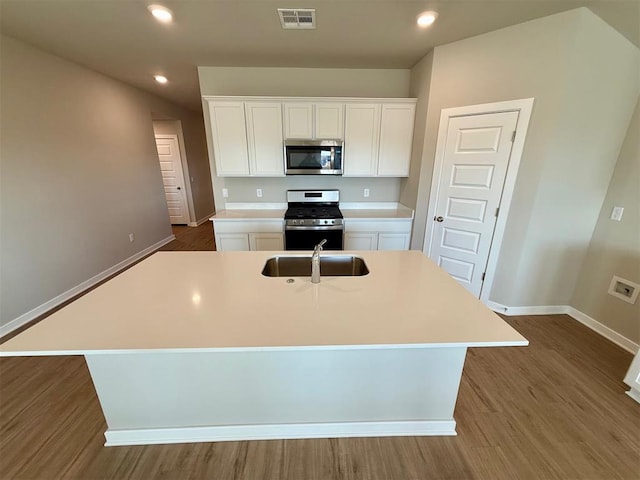 kitchen featuring appliances with stainless steel finishes, sink, white cabinetry, and an island with sink