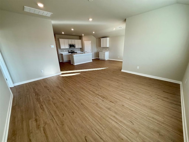 unfurnished living room featuring light wood-type flooring and vaulted ceiling