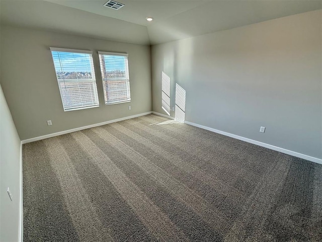 empty room with vaulted ceiling and carpet flooring