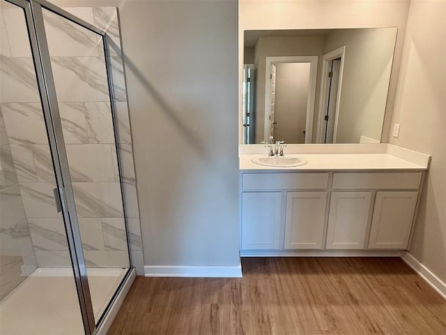 bathroom featuring vanity, wood-type flooring, and walk in shower