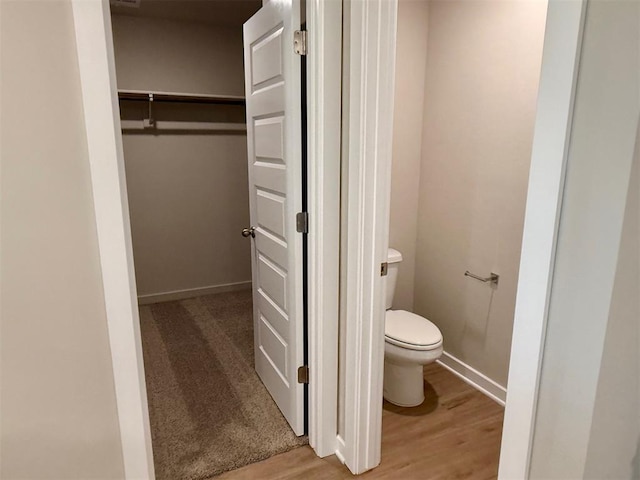 bathroom featuring toilet and wood-type flooring