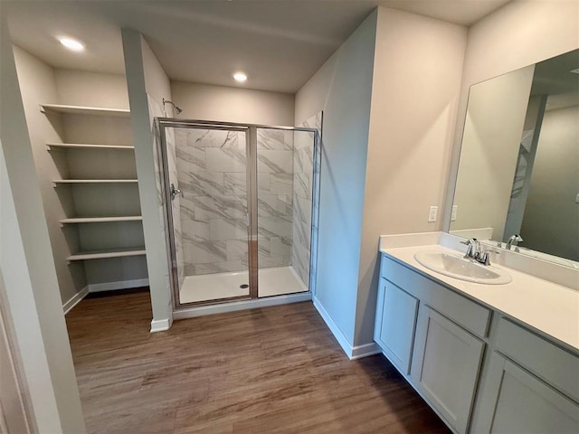 bathroom with vanity, hardwood / wood-style flooring, and a shower with door