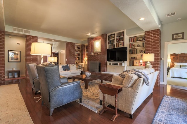 living room with brick wall and dark hardwood / wood-style floors