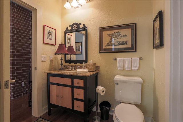 bathroom featuring vanity, hardwood / wood-style flooring, and toilet