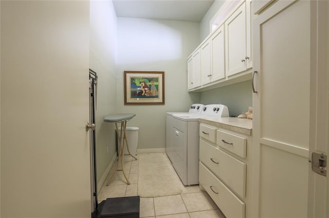 laundry area featuring cabinets, washing machine and dryer, and light tile patterned flooring