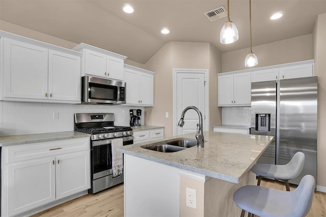 kitchen with stainless steel appliances, white cabinetry, hanging light fixtures, and sink