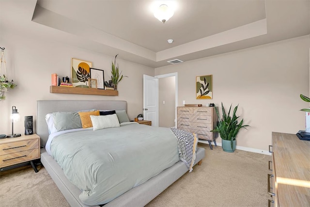 bedroom with carpet flooring and a raised ceiling