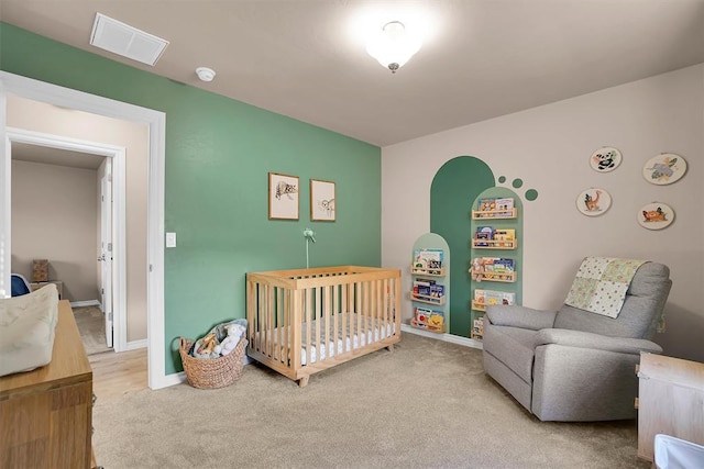 bedroom with carpet flooring and a nursery area