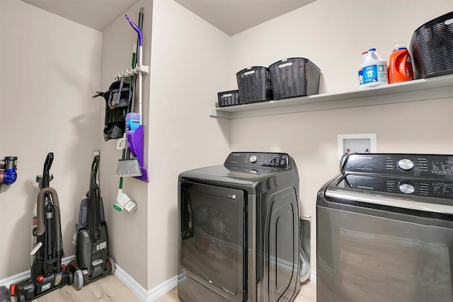 laundry area featuring light hardwood / wood-style floors and washing machine and clothes dryer