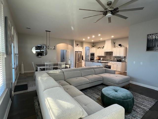 living room featuring dark hardwood / wood-style flooring and ceiling fan