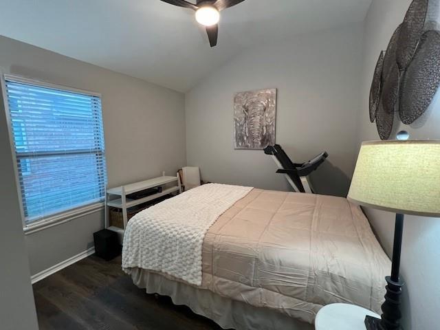 bedroom with dark hardwood / wood-style floors, ceiling fan, and vaulted ceiling