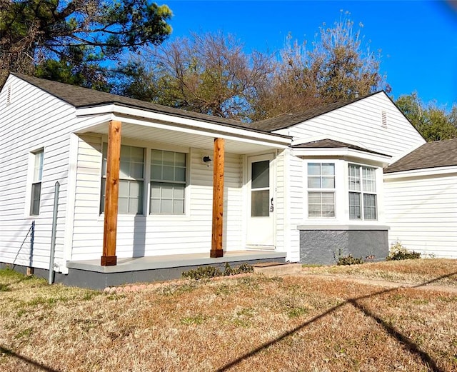 view of front of house with covered porch and a front yard