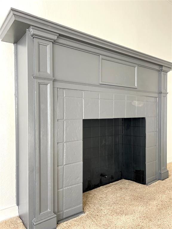 details featuring a tile fireplace, crown molding, and carpet floors