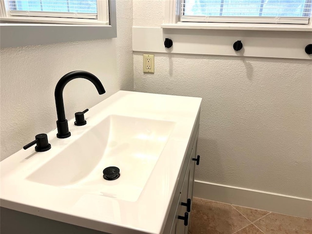 bathroom with tile patterned floors, vanity, and a wealth of natural light