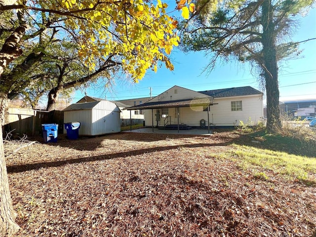 back of property with a storage shed and a patio