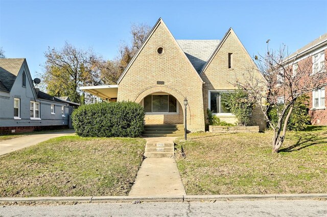 tudor-style house with a front lawn