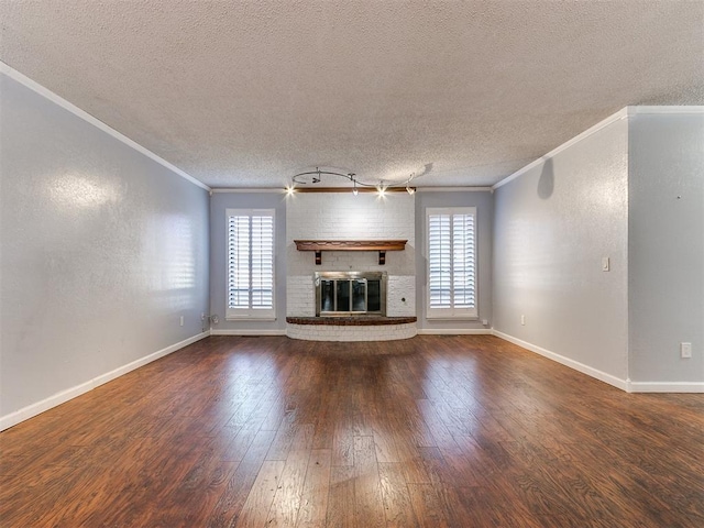 unfurnished living room with a fireplace, a textured ceiling, dark wood-type flooring, and ornamental molding