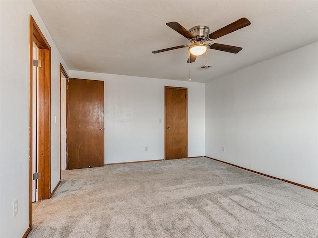 unfurnished bedroom with ceiling fan and light colored carpet