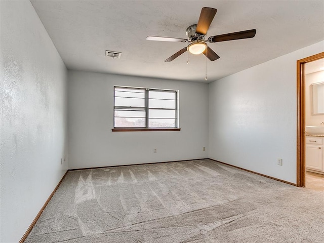 carpeted spare room featuring ceiling fan