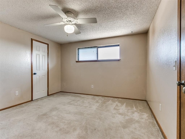 empty room with light carpet, a textured ceiling, and ceiling fan